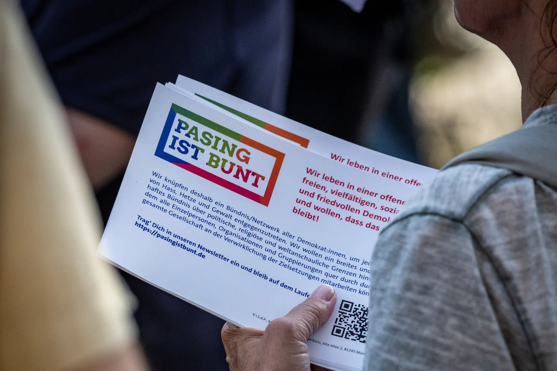 Hand hält Pasing-ist-bunt-Flyer